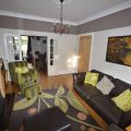 Living room is connected to the dining room by double doors. There are two arm chairs and one long sofa